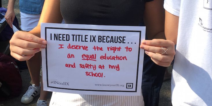An activist holds up a poster during a recent protest against changes in Title IX legislation in the U.S. (Photo/ Know Your IX)