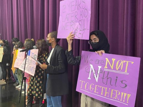 Protesters hold posters at NU-Q Townhall